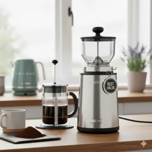 A stainless steel Cuisinart burr grinder with a Best Value tag, positioned next to a glass cafetière and fresh ground coffee.