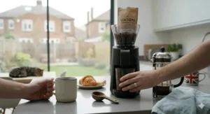 A calm morning kitchen scene featuring the quietest coffee grinder, emphasising a peaceful start to the day with a cat resting in the background.