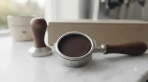 A perfectly compressed coffee puck created using a wooden espresso tamper.