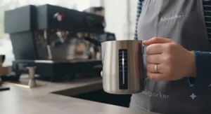 Coffee milk pitcher featuring an adhesive temperature strip for monitoring milk steaming heat.